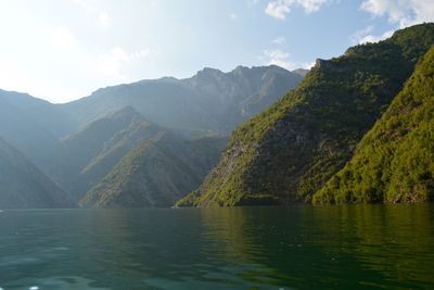 Scenic view of lake by mountains against sky
