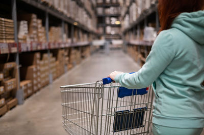 Rear view of woman holding shopping cart