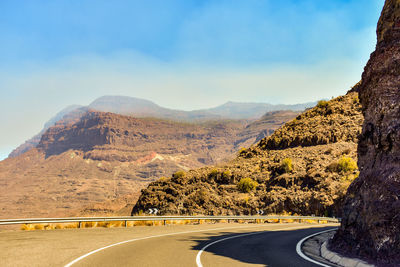 Road amidst mountains against sky