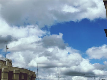 Low angle view of buildings against cloudy sky