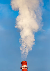 Low angle view of smoke stacks against sky