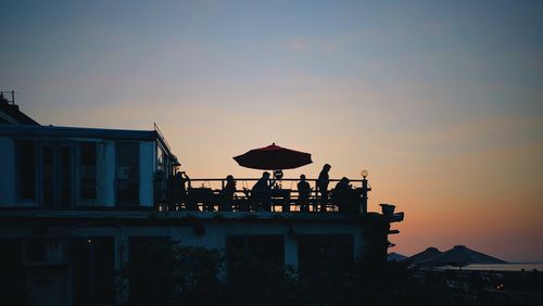 Silhouette buildings against sky at sunset