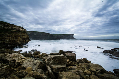 Rocks by sea against sky