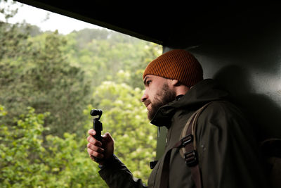 Rear view of man photographing against sky