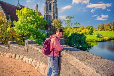 A beautiful young  woman stands on a stone bridge near the st. albans church. copenhagen, denmark