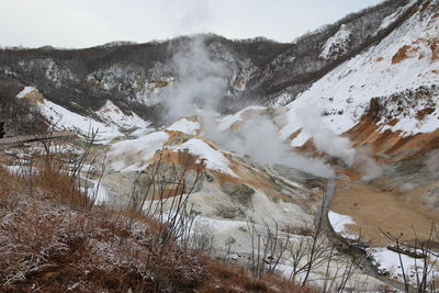 Smoke emitting from volcanic geyser against sky