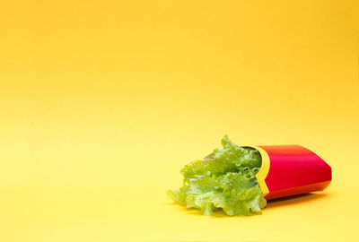 Close-up of fresh red chili pepper against yellow background