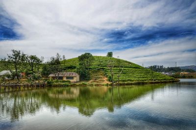 Houses by lake and buildings against sky