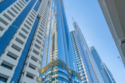 Low angle view of modern buildings against clear blue sky