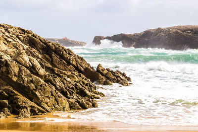 Scenic view of rocks in sea against sky