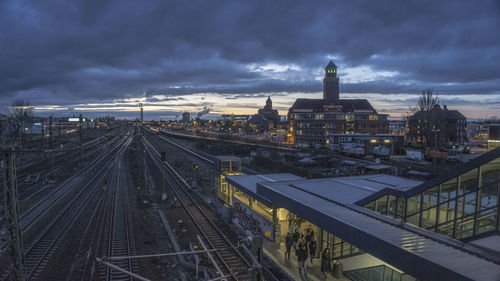 High angle view of railroad tracks in city against cloudy sky