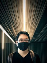 Portrait of young man standing in corridor