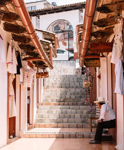 Low angle view of woman hanging on ceiling of building