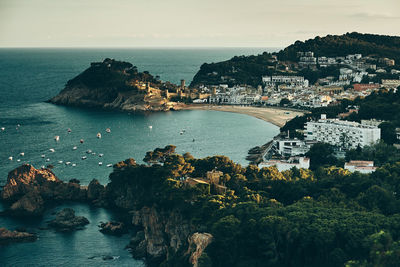 High angle view of city by sea against sky