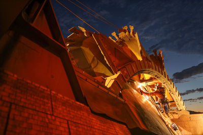 Low angle view of illuminated building against sky at night