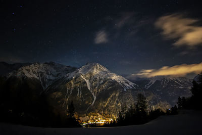 Scenic view of snowcapped mountains against sky at night