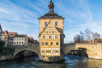 Arch bridge over river against buildings