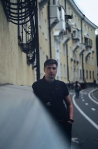 Portrait of young man standing in city