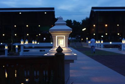 Illuminated street light against building at night