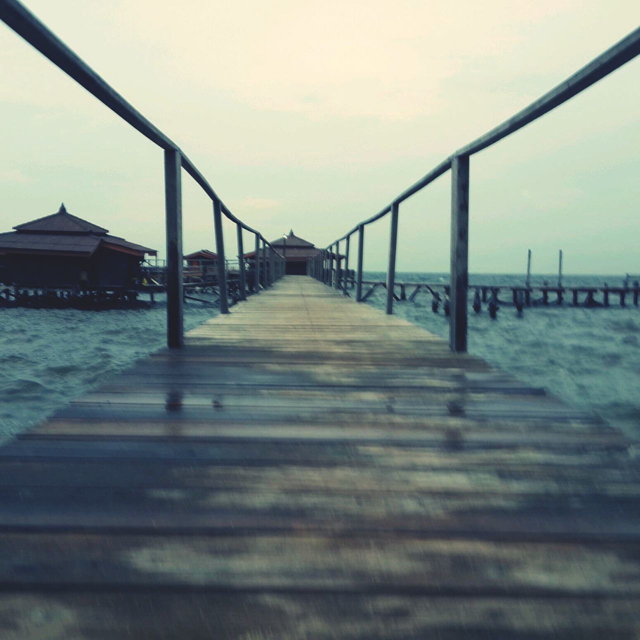 sea, pier, water, the way forward, sky, railing, diminishing perspective, built structure, horizon over water, beach, wood - material, long, tranquility, tranquil scene, nature, architecture, vanishing point, connection, scenics, surface level