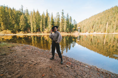 Man standing by lake against sky