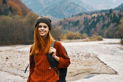 Portrait of smiling young woman standing on mountain