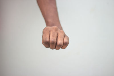 Close-up of hand over white background