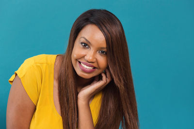 Portrait of a smiling young woman against blue background