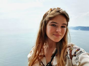 Portrait of beautiful woman against sea and sky