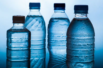 Close-up of bottles on table against blue background