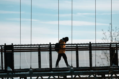 Full length of woman walking on bridge during winter