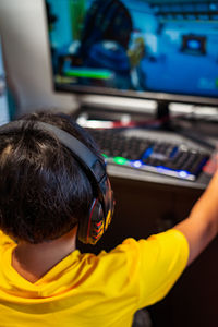 A gamer or a streamer boy with a gamepad playing with friends on the networks in video games.