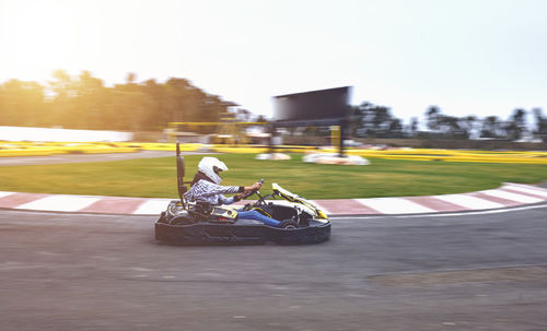 A driver in gear and helmet drives a racing car. go karts racing, street karting, rent, copy space