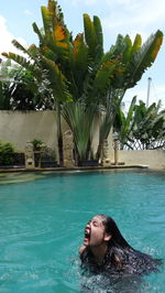 Woman in swimming pool against trees