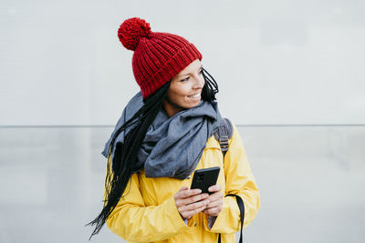 Young woman using mobile phone while standing outdoors