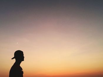 Silhouette man standing against sky during sunset