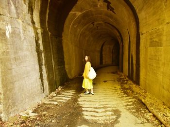 Rear view of man standing in tunnel 