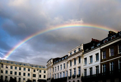 Rainbow over buildings against sky