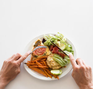 Close-up of man holding food against white background