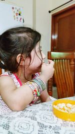 Close-up of baby girl sitting at home