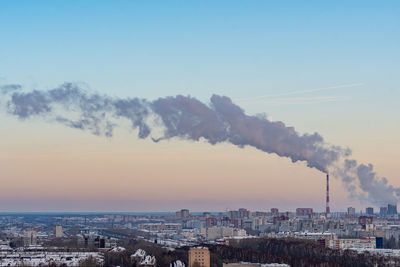 Smoke emitting from chimney against sky