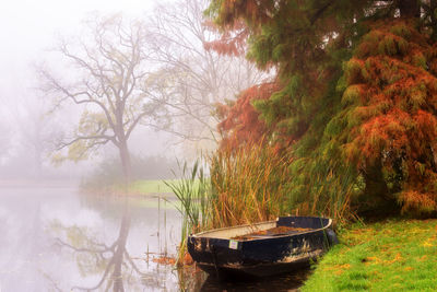 Boat in lake against trees during autumn