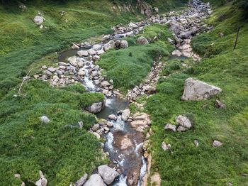 High angle view of stream amidst rocks