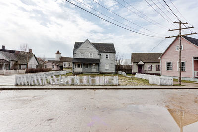 Houses by street against sky