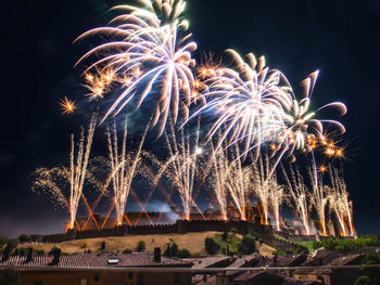 Low angle view of firework display at night