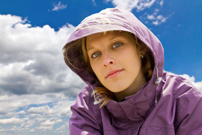 Close-up portrait of woman in warm clothing against sky