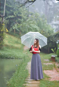 Woman with umbrella standing in rain