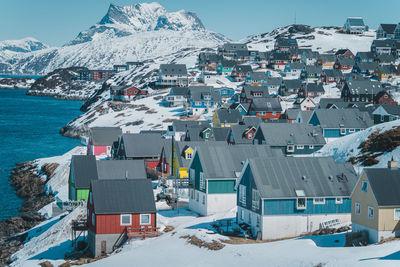 High angle view of townscape by snowcapped mountains