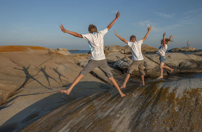 Full length of children at beach against sky