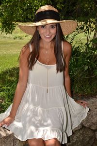 Portrait of happy young woman wearing sun hat on field